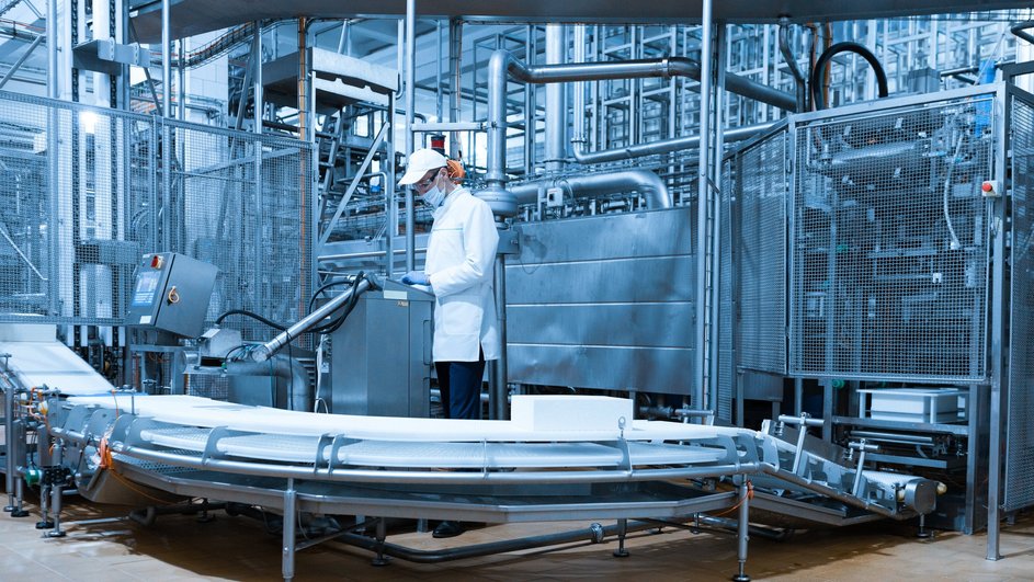 Работник стоит на производстве крабовых палочек Работник стоит на производстве крабовых палочек