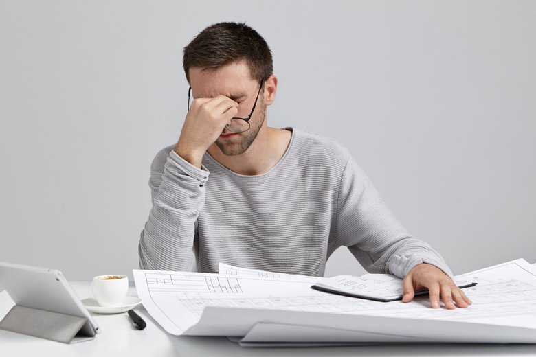 Усталый мужчина на работе Усталый мужчина на работе