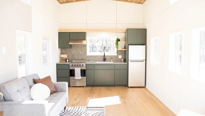 Жилая зона включает кухню с холодильником, духовкой с электрической варочной панелью, встроенной посудомоечной машиной и шкафом.