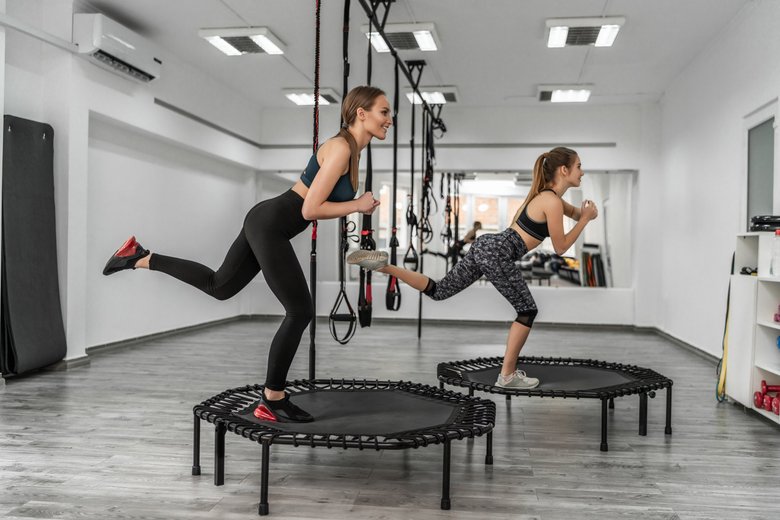 Девушки занимаются спортом на мини-батутах Девушки занимаются спортом на мини-батутах