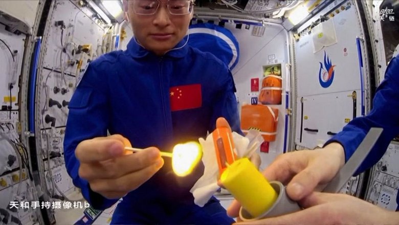 Астронавты Гуй Хайчао и Чжу Янчжу зажигают свечу на борту космической станции «Тяньгун».