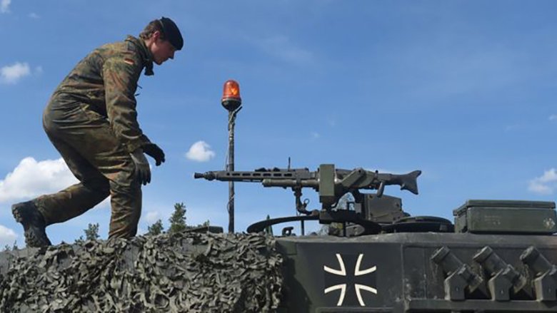 Германский танкист на башне танка Leopard 2, который вооружен пулеметом MG3. Фото: Getty Images