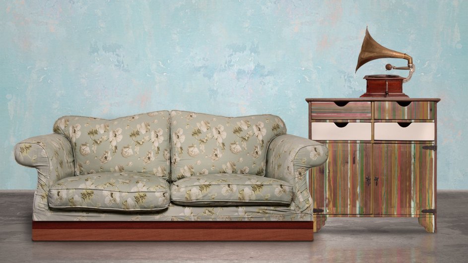 Ретро диван и тумбочка с граммофоном на фоне стены 