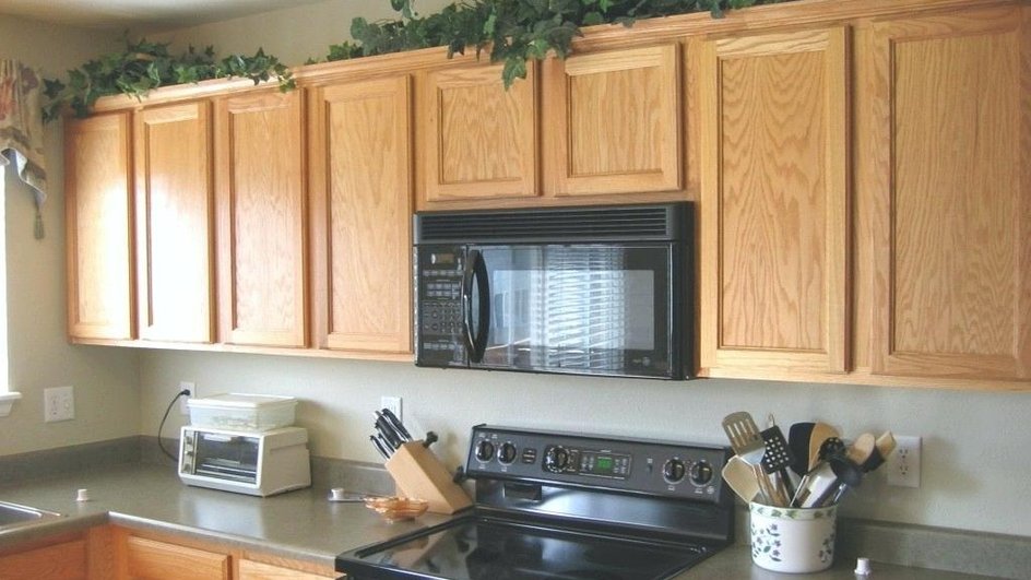 Кухонные шкафы из светлого дерева весят над плитой