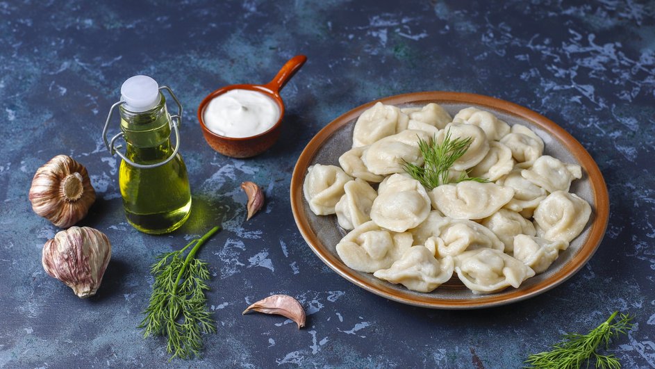 Пельмени с фаршем и картошкой, украшенные зеленью Пельмени с фаршем и картошкой, украшенные зеленью