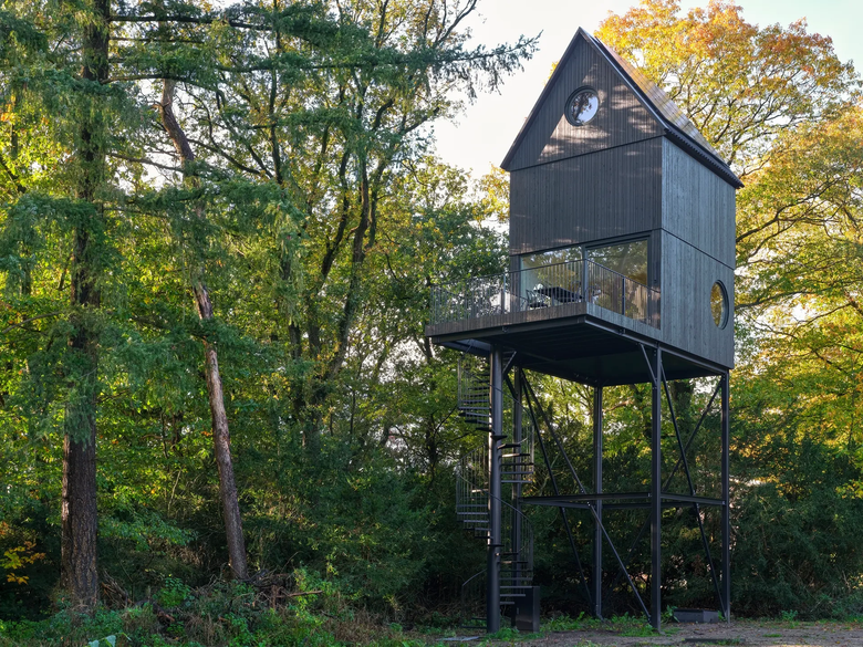 Дом возвышается на 7,5 м над лесом на тонких опорах из черной стали.