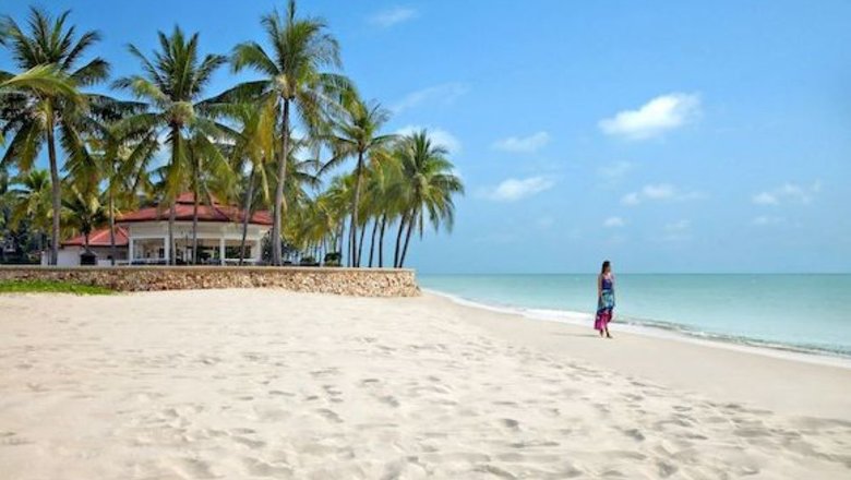 Девушка идет по пляжу с поющими песками в Таиланде.