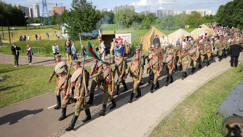 Участники военно-исторической реконструкции шагают строем во время фестиваля Времена и эпохи