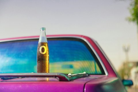 Безалкогольное пиво на багажнике красного автомобиля