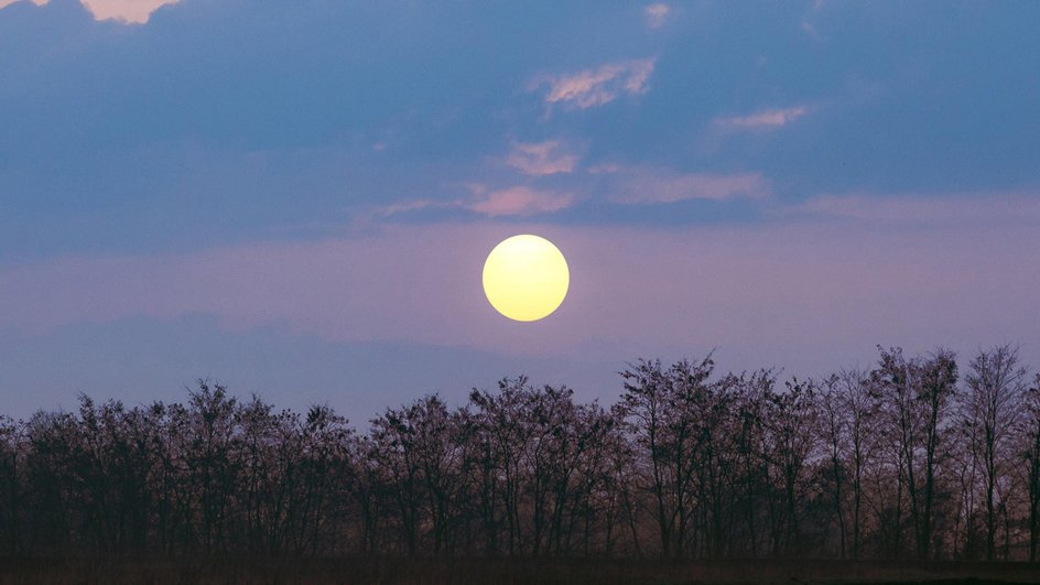 Тусклое солнце на вечернем небе