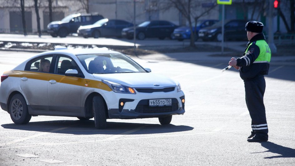 Сотрудник ГИБДД останавливает автомобилиста Сотрудник ГИБДД останавливает автомобилиста