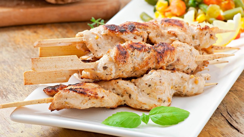 Домашний шашлык из курицы лежит на тарелке Домашний шашлык из курицы лежит на тарелке