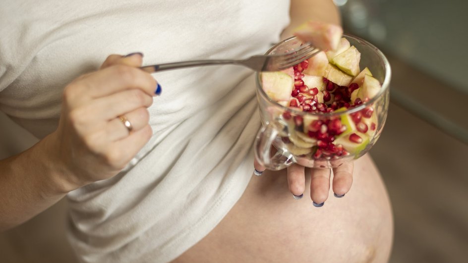 беременная женщина ест фрукты