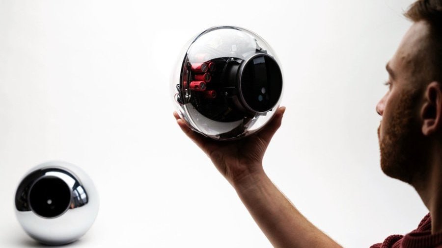 Человек держит устройство Orb в руке перед сканированием глаза Человек держит устройство Orb в руке перед сканированием глаза