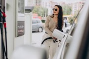 Девушка заправляет автомобиль на АЗС