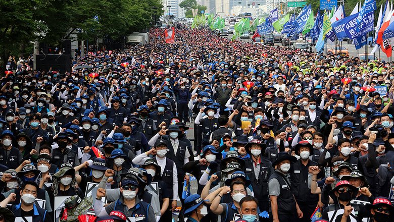 Рабочие в защитных масках проводят митинг против политики правительства в области труда в Сеуле, Южная Корея