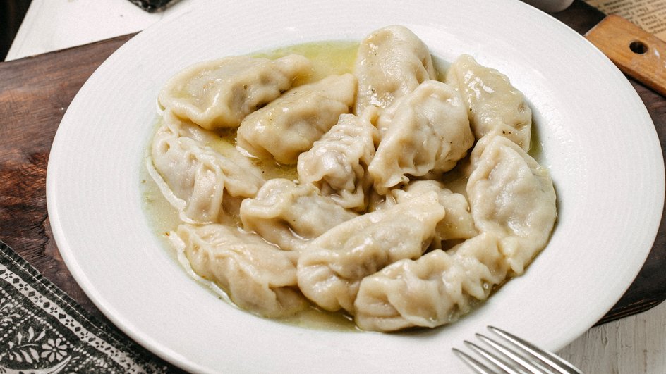 Домашние вареники с сыром лежат на тарелке