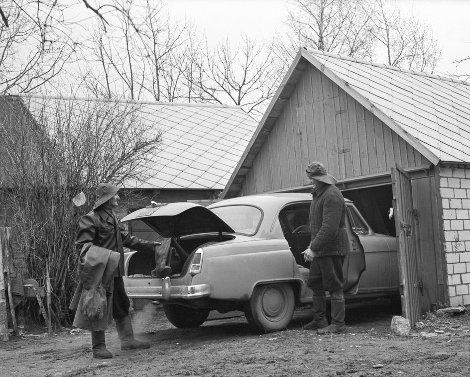 СССР. 1 апреля 1967 г. Отец и сын около своей машины рядом с гаражом