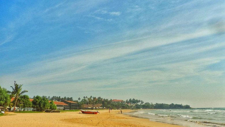 Лодка на пляже и чистейшие воды Bentota Beach, Шри-Ланка.