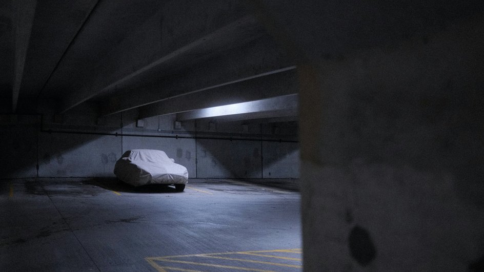 Автомобиль на подземной парковке под чехлом