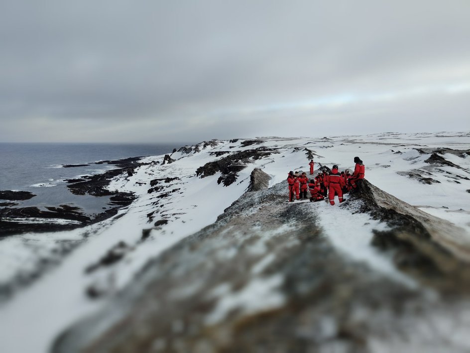 Группа туристов на снежной горе рядом с морем