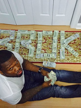 Content image for: 489524 | Рэпер 50 Cent позирует с поддельными деньгами (фото)
