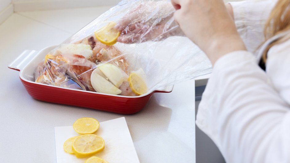 Девушка кладет сырой шашлык с овощами в руках для запекания