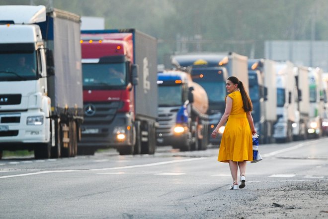 Девушка переходит дорогу по которой движутся грузовые автомобили на Московском малом кольце (бетонке) в Москве. Новые правила передвижения грузовиков тяжелее Девушка переходит дорогу по которой движутся грузовые автомобили на Московском малом кольце (бетонке) в Москве. Новые правила передвижения грузовиков тяжелее