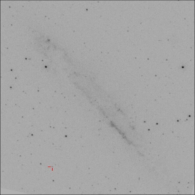 Одно из изображений, на котором обнаружили TUVO-21acq (положение выделено красным). Также хорошо видна спиральная галактика NGC 4945 в центре. Источник: phys.org