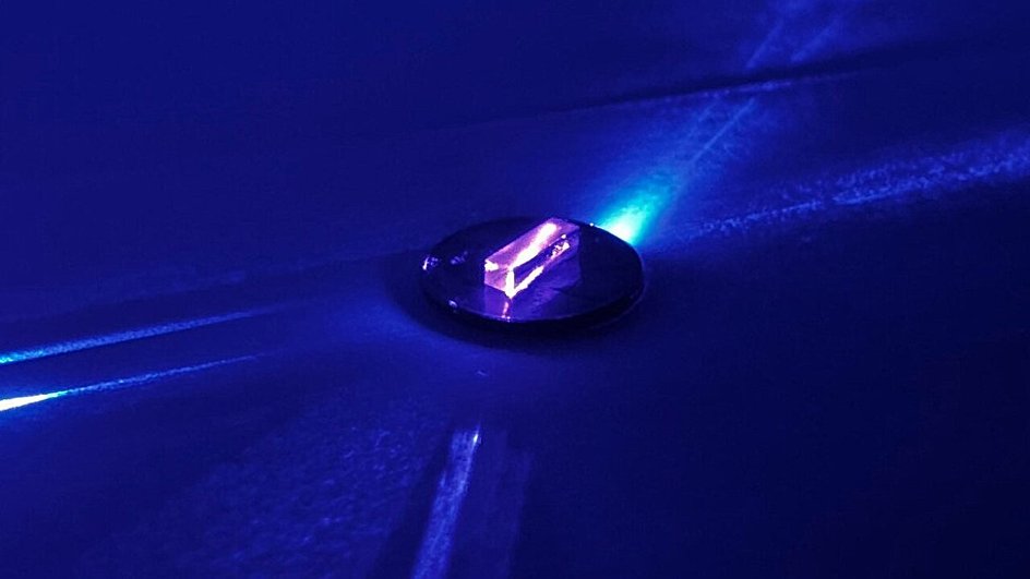Лазерный свет проходит через прозрачный кристалл и возбуждает ядро ​​тория