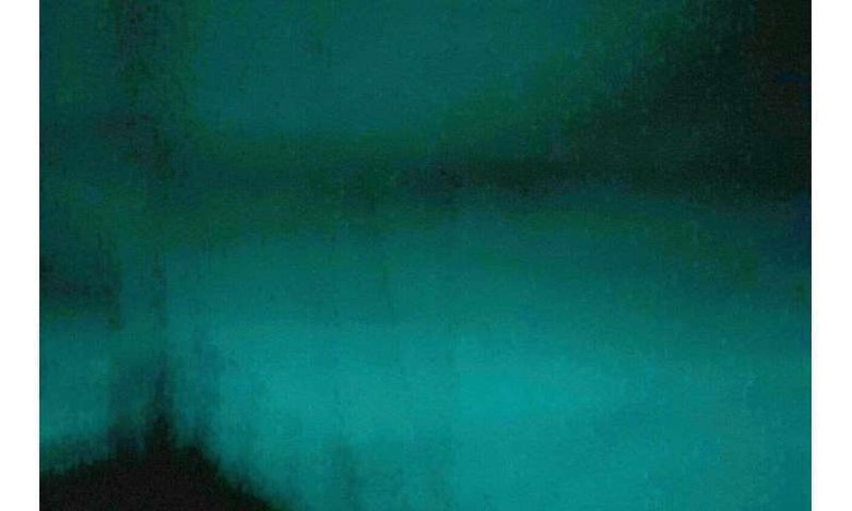 Ночная фотография «молочного моря», сделанная 2 августа 2019 года. Палуба корабля вырисовывается силуэтом на фоне свечения воды. Фото: Australian National University