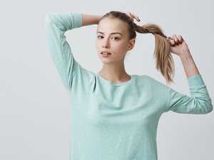 Девушка завязывает хвост