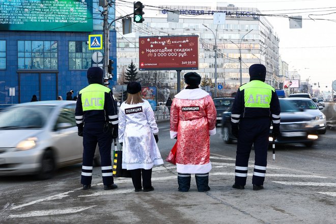 Сотрудники Госавтоинспекции в костюмах Снегурочки и Деда Мороза во время всероссийской акции "Полицейский Дед Мороз".