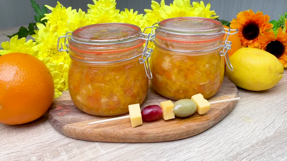 Две банка варенья из лимонов с апельсином кусочками стоят на столе рядом с канапе Две банка варенья из лимонов с апельсином кусочками стоят на столе рядом с канапе