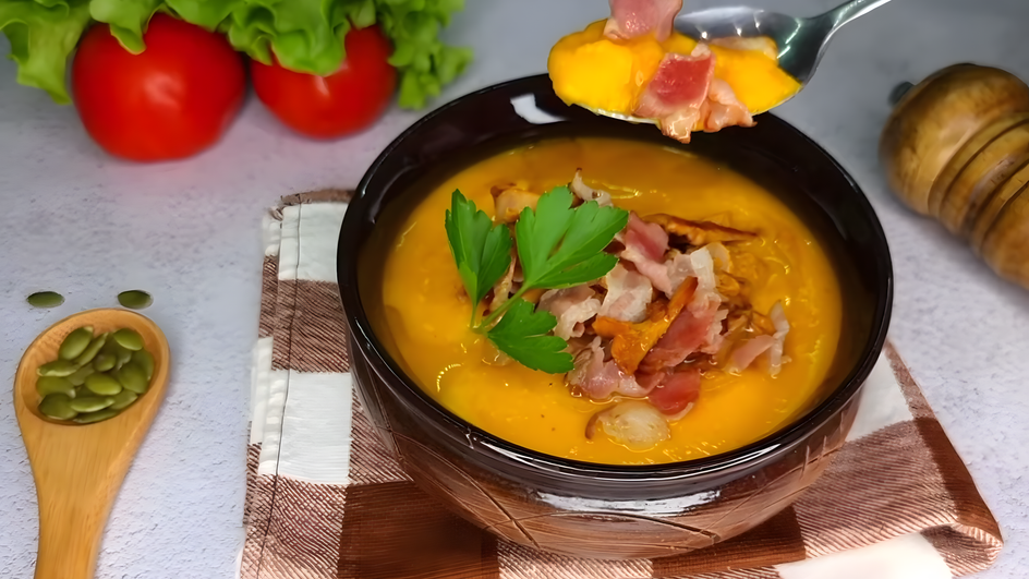 Суп-пюре с лисичками и беконом, украшенный жареными лисичками, ломтиками бекона и листиком петрушки, поданный в темной миске на клетчатой салфетке Суп-пюре с лисичками и беконом, украшенный жареными лисичками, ломтиками бекона и листиком петрушки, поданный в темной миске на клетчатой салфетке