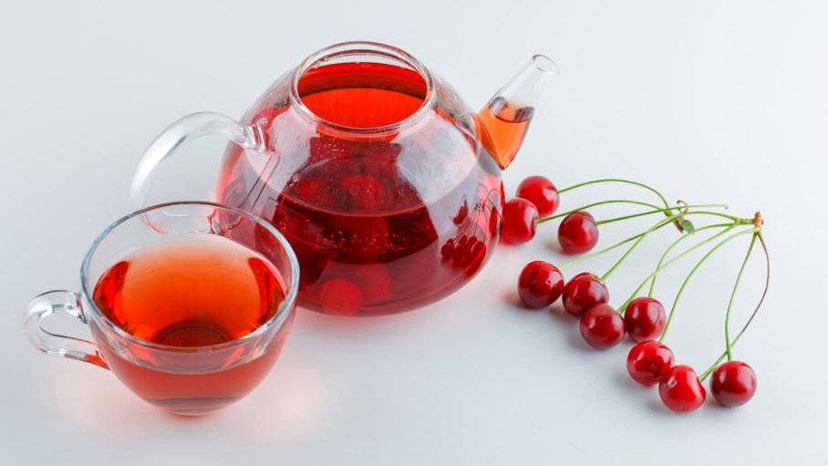 Компот из вишни с косточками в чашке и чайнике 