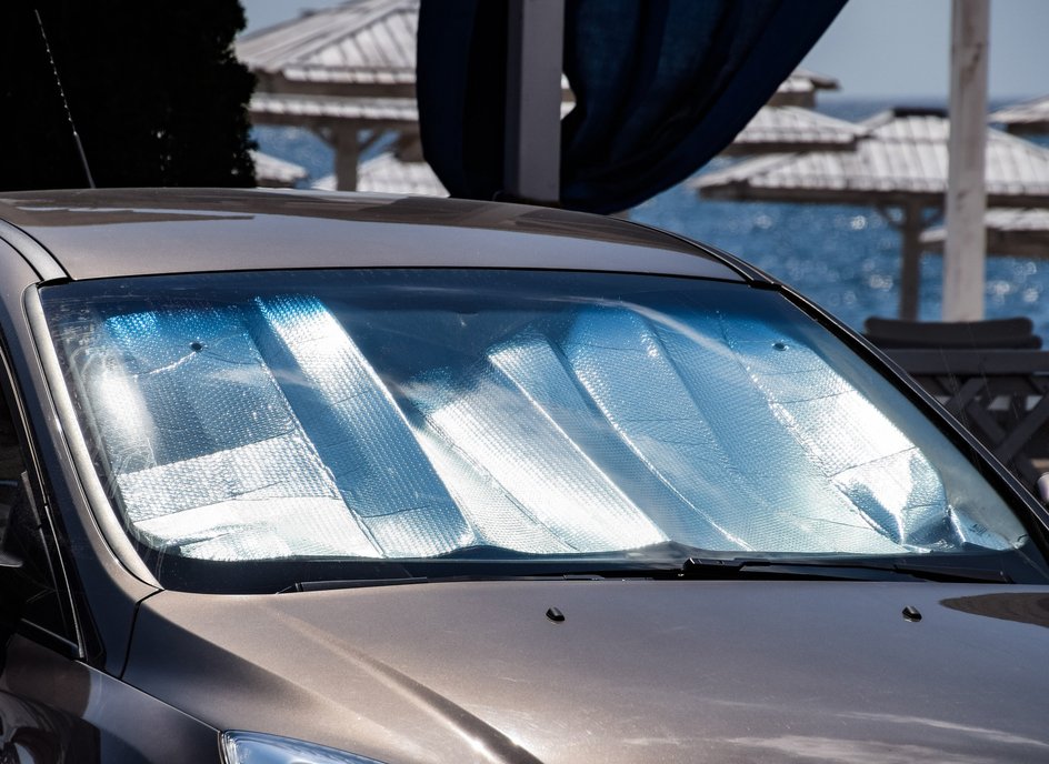 Солнцезащитный экран под стеклом автомобиля в жару