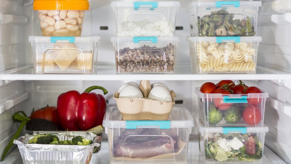 Продукты в пластиковых контейнерах стоят на полках холодильника