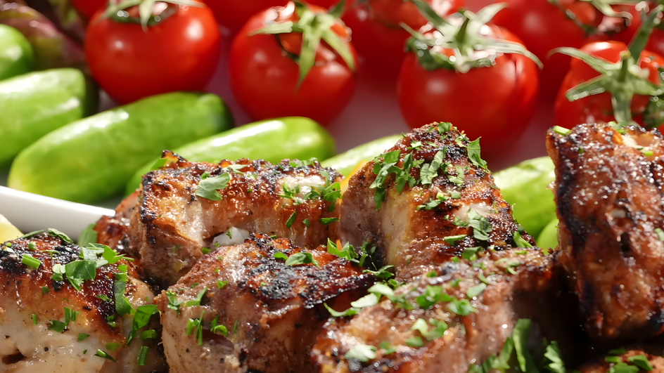 Шашлык из рыбы с зеленью лежит рядом с овощами