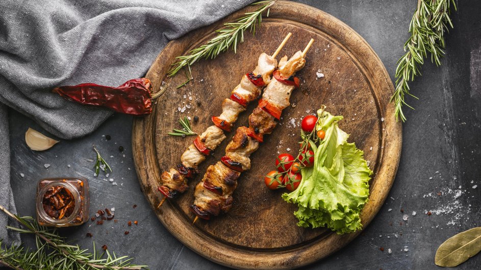 Шашлык из курицы на деревянных шпажках, украшенный овощами Шашлык из курицы на деревянных шпажках, украшенный овощами