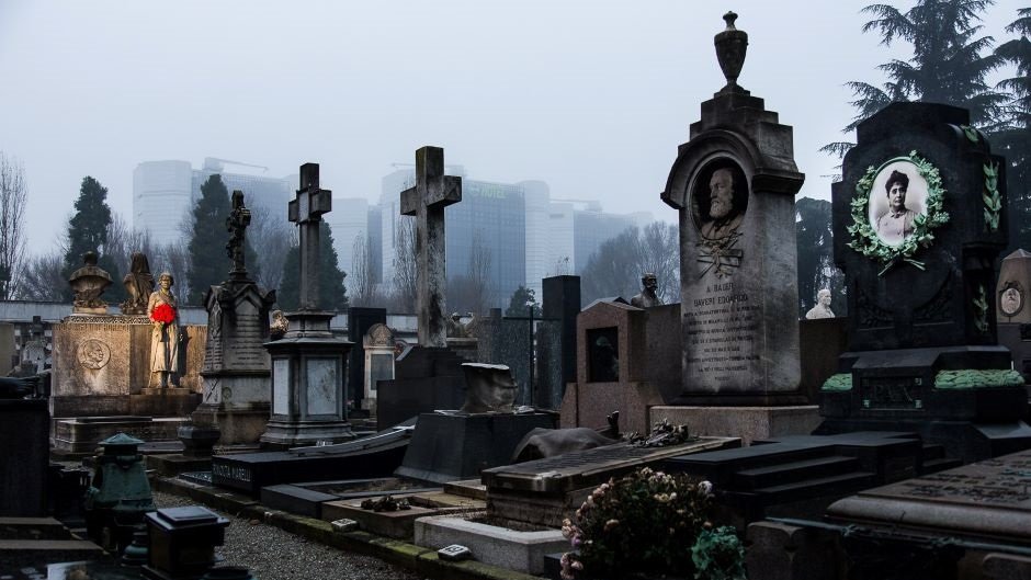 Могильные плиты с крестами стоят на вечернем кладбище 