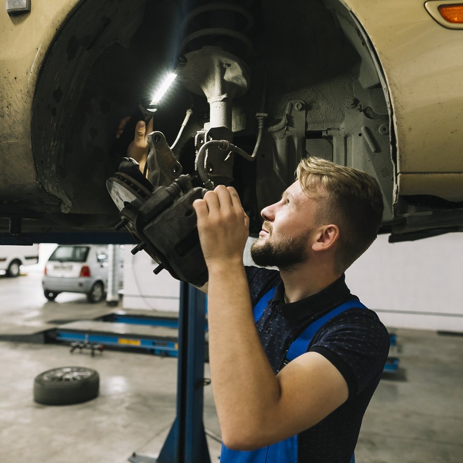 Автомеханик проверяет колесные арки автомобиля