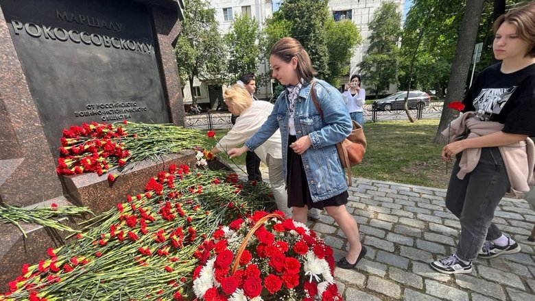 Люди возлагают цветы к мемориалу в День памяти и скорби.