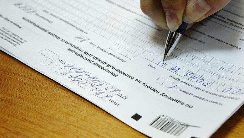 Женщина заполняет налоговую декларацию. Женщина заполняет налоговую декларацию.