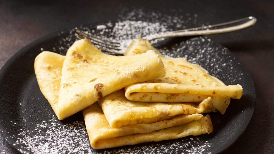 Вкусные блины с бананом и яблоком на кефире лежат на тарелке Вкусные блины с бананом и яблоком на кефире лежат на тарелке