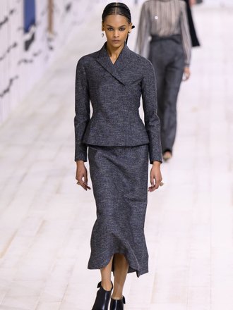 Модель в костюме с юбкой макси на показе Dior
