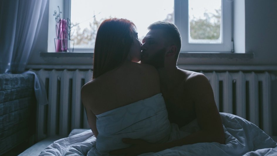 Мужчина и женщина целуются на фоне окна Мужчина и женщина целуются на фоне окна