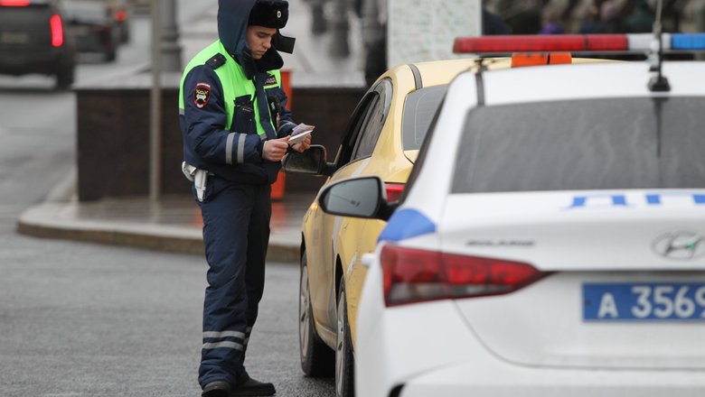 Сотрудник ГИБДД проверяет документы автомобилиста