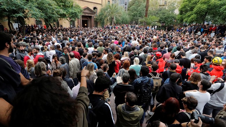 Люди около входа на избирательный участок в Барселоне.