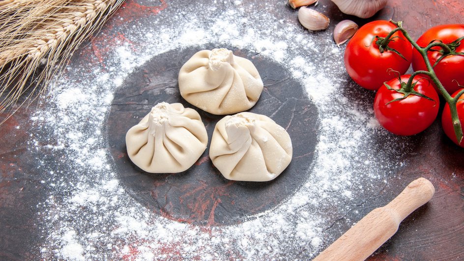 Сырые вегетарианские хинкали с грибами лежат на столе